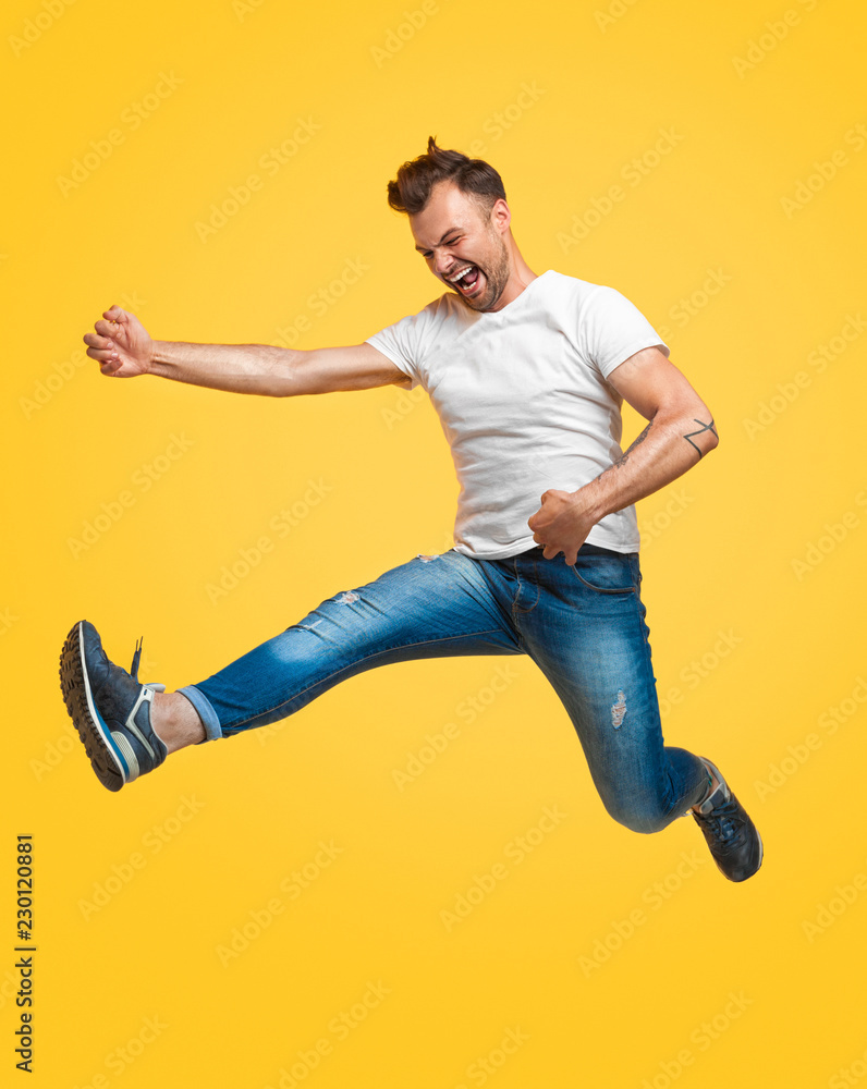 Man jumping and pretending to play guitar Man jumping and pretending to play guitar