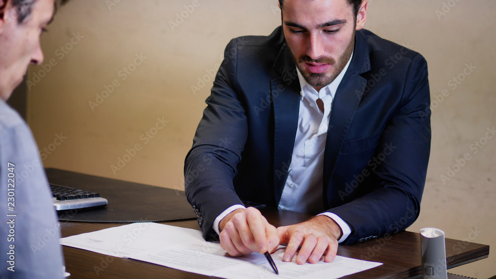Handsome businessman sitting in his office, talking to client or other businessman or colleague and discussing with him on business proposals, projects or demands. Handsome businessman sitting in his office, talking to client or other businessman or colleague and discussing with him on business proposals, projects or demands.