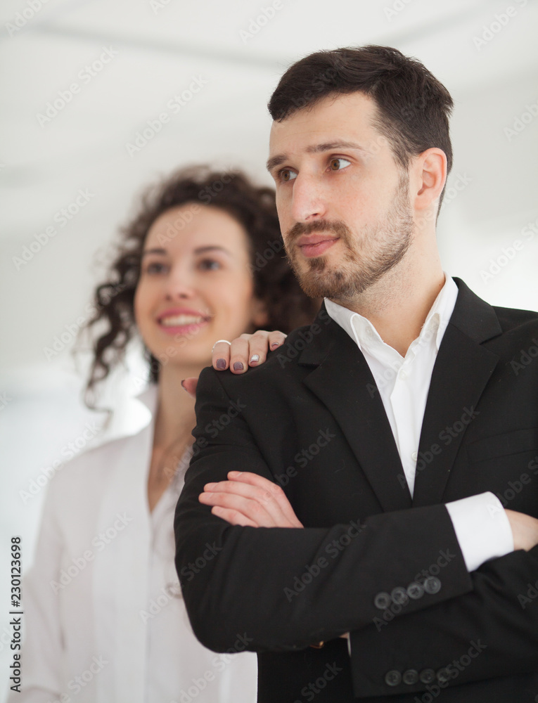 Attractive stylish business people, team leader or manageress posing in front of a female colleague smiling confidently at the camera Attractive stylish business people, team leader or manageress posing in front of a female colleague smiling confidently at the camera
