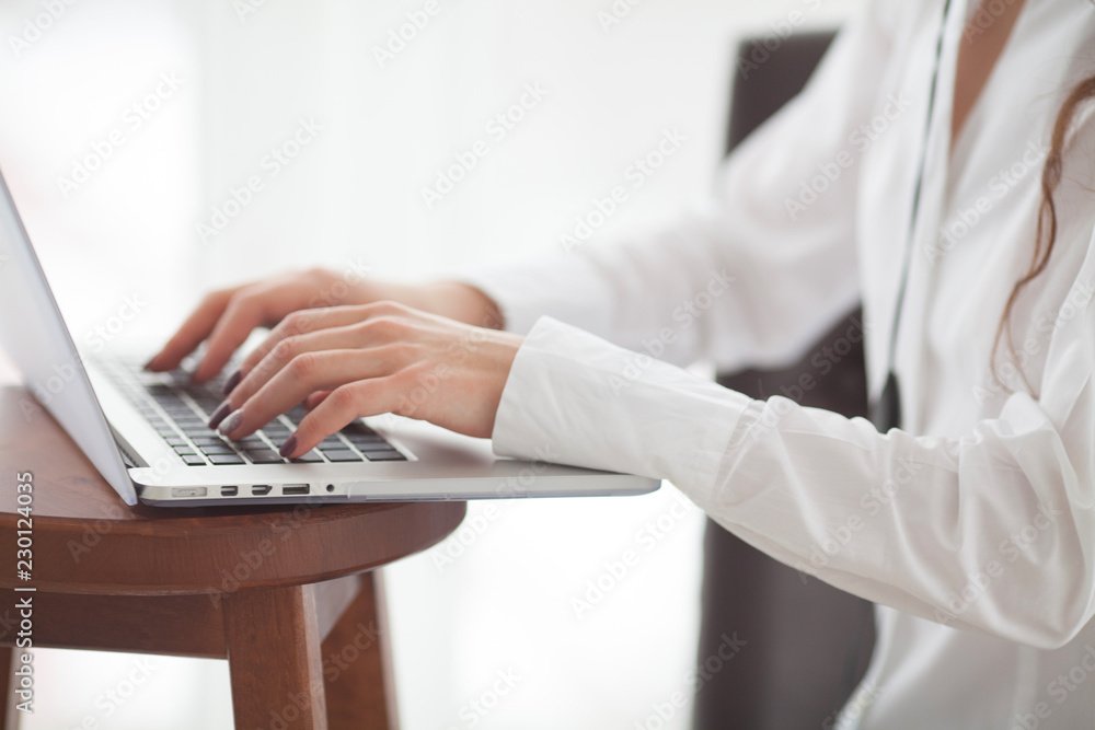 Woman's hands typing on laptop keyboard Woman's hands typing on laptop keyboard