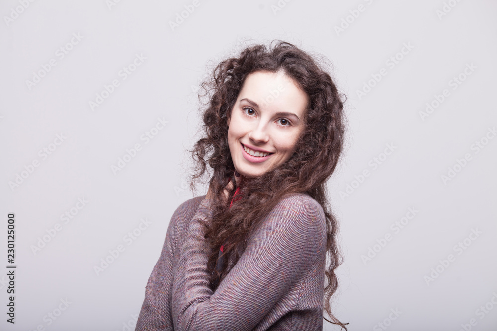Obraz premium Glamour girl in dress on white. Woman with curly hair. Happy teacher. Warm dress. Smiling woman