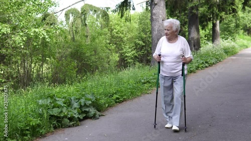 grandmother walks with Nordic walking sticks old grey photo