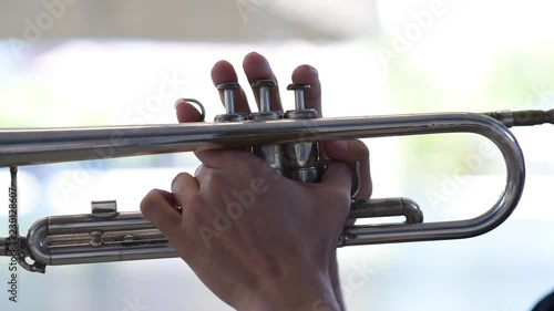 Hands of man pushing button and holding on brazen trumpet close up. Fingers of man pushing button on trumpet close up.
