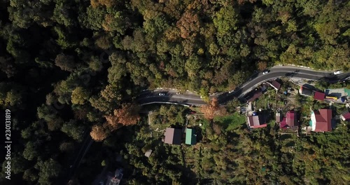 Top down view of cars on a curvy road. Aerial drone shoot in the mountains.