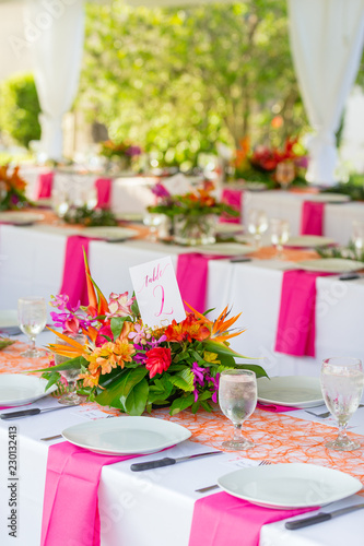 details of flowers  plates and glasses under outdoor tent wedding