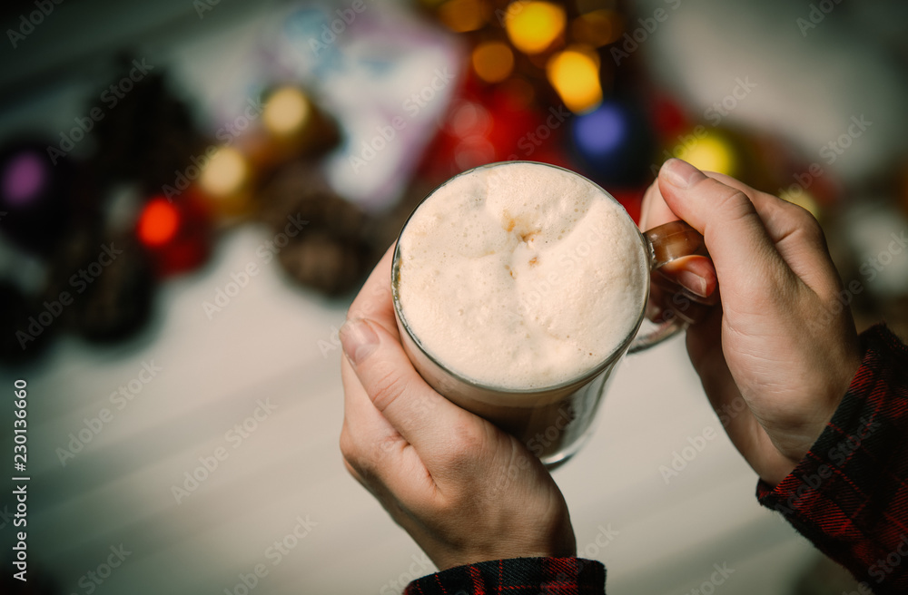 photo of the child  hands holding  cup of coffee on the christmas decorations background