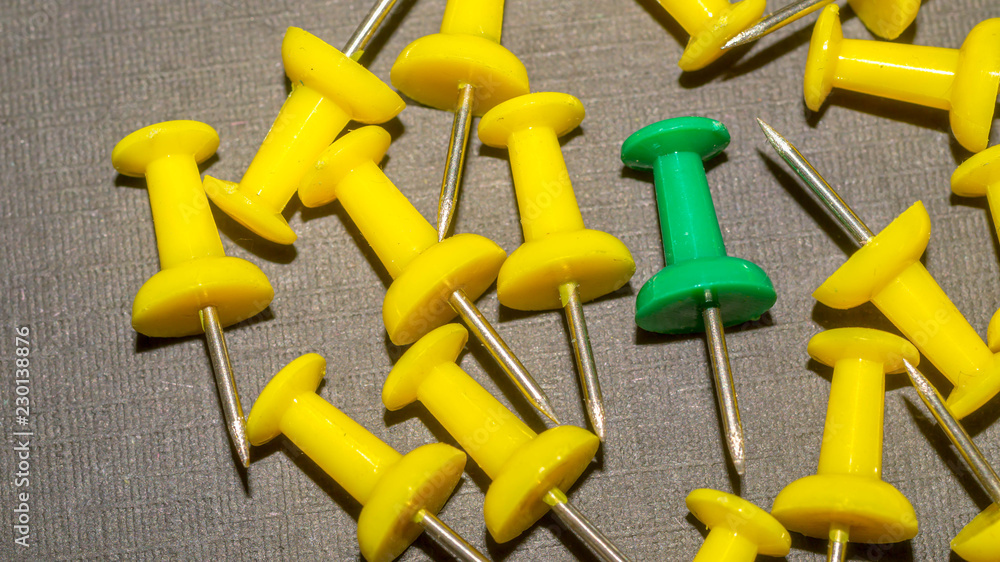 green surrounded by yellow push pins. difference and minority concept green surrounded by yellow push pins. difference and minority concept