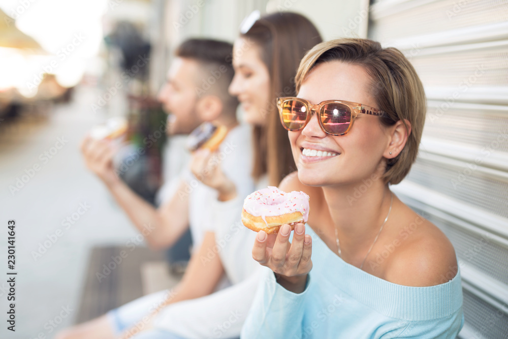 Beautiful young woman eating a donut Beautiful young woman eating a donut