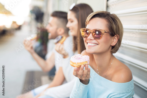 Beautiful young woman eating a donut