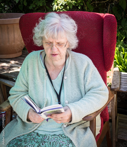 Grandma reading in the back garden, Southampton, UK