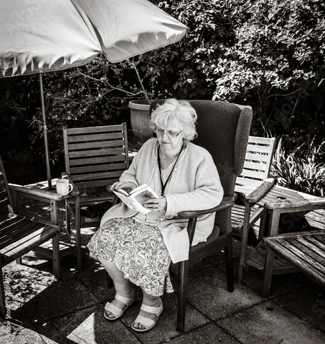 Black and White picture of grandma reading in the garden