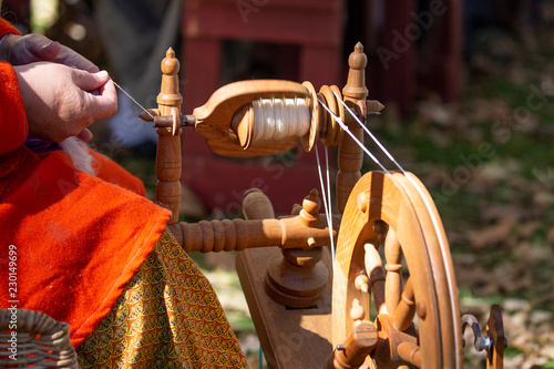 Making yarn with old-fashioned spinning wheel
