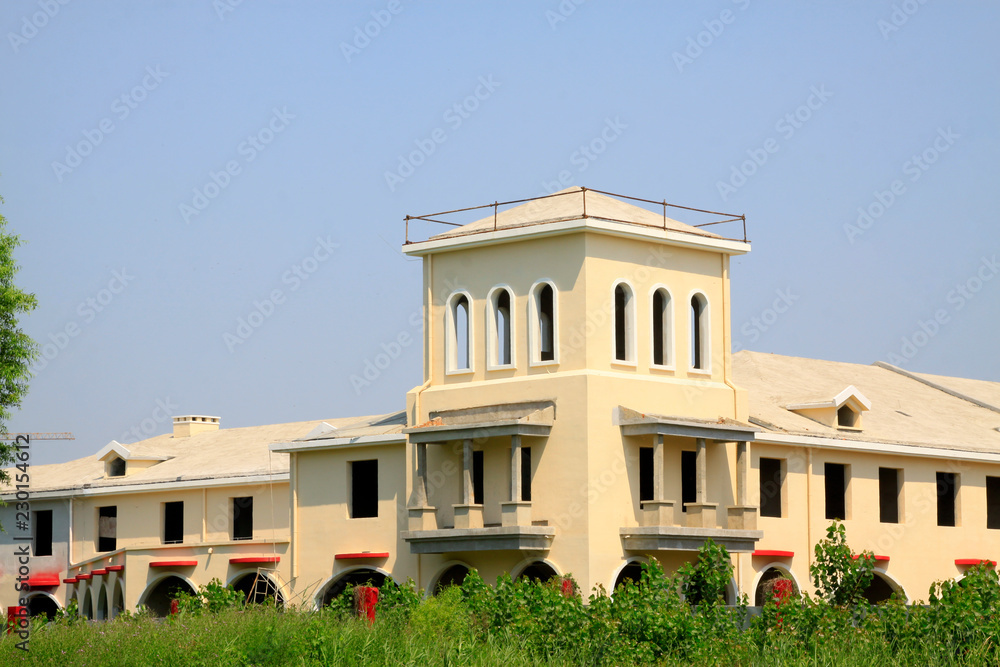 Obraz premium Unfinished building and green plants