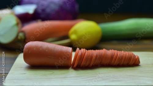 Carrot sliced. Carrot cut into pieces on a wooden board. Stop Motion Animation 4K.