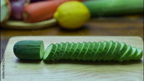 Cucumber sliced Cucumber cut into pieces on a wooden board. Stop Motion Animation 4K.