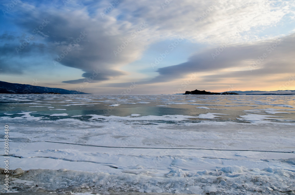 Frozen Lake Baikal. Beautiful stratus clouds over the ice surface on a frosty day.