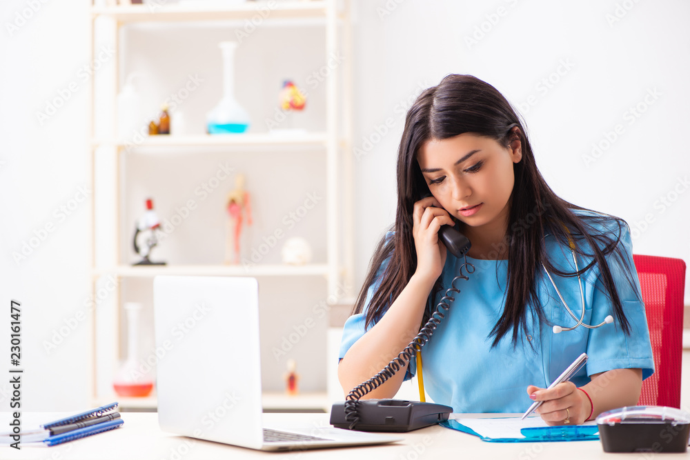 Young beautiful female doctor working in the clinic Young beautiful female doctor working in the clinic