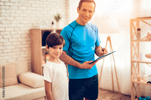 Boy and Smiling Man in Sports Uniform in Apartment