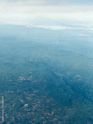 An aerial view of Thailand fields and mountains with Khao Laem National Park in the background