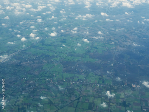 An aerial view of clouds and skies and fields from an airplane (flying over Southeast Asia - Thailand, Vietnam)