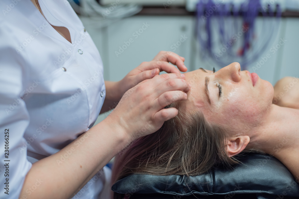 Side view of the face of a young girl during a manual face massage at the spa. Anti-aging facial massage for a beautiful blonde woman. Masseuse doing shiatsu massage to woman Side view of the face of a young girl during a manual face massage at the spa. Anti-aging facial massage for a beautiful blonde woman. Masseuse doing shiatsu massage to woman