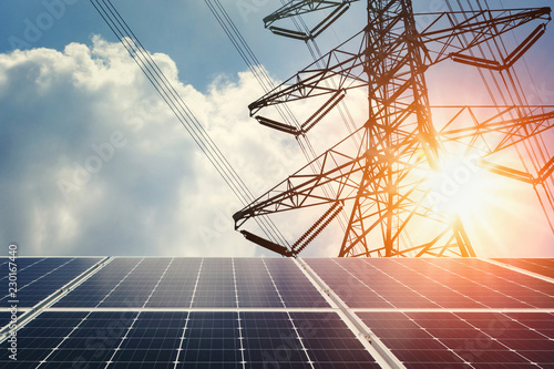 solar panel and high voltage tower with sunshine. clean energy power concept photo