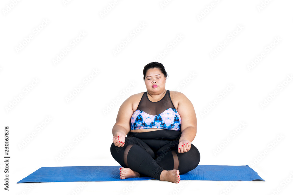 Fototapeta premium Fat woman meditating on studio