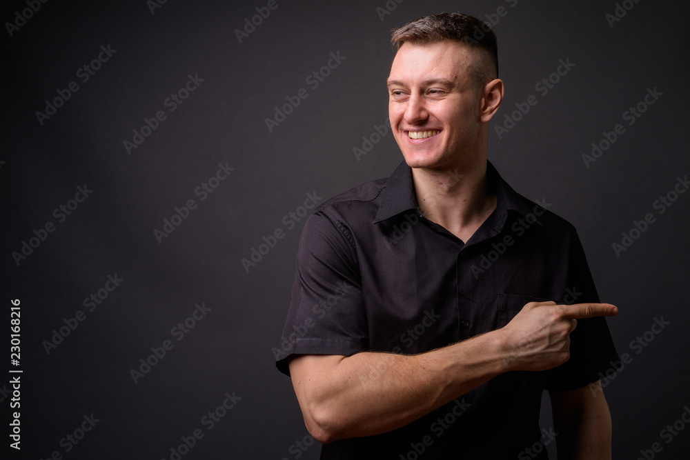 Young handsome businessman smiling and pointing finger Young handsome businessman smiling and pointing finger