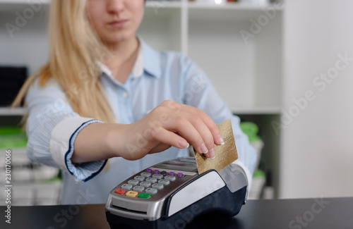 Administrator at gym using payment terminal for paying by credit card photo