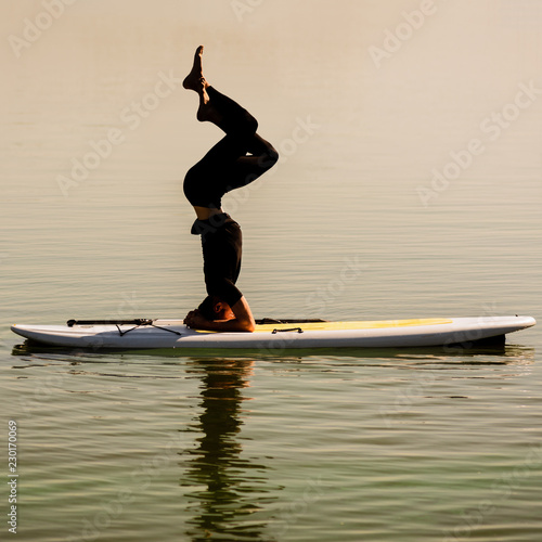 Silhouette of young flexible man on sup yoga meditation