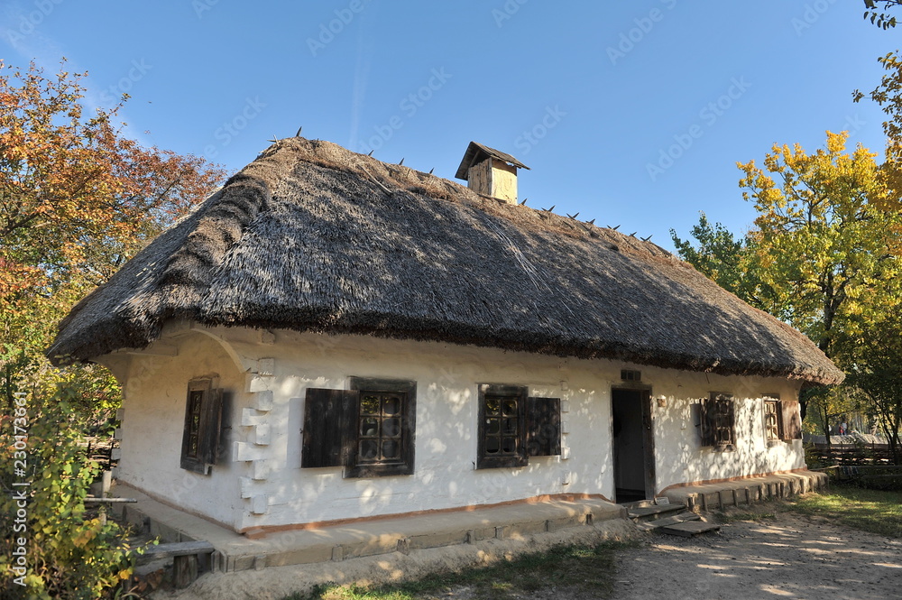 House under the thatched roof in the village. Autumn. House under the thatched roof in the village. Autumn.