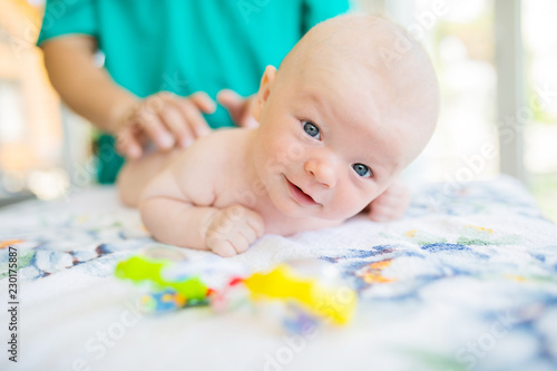 Doctor masseur wearing uniform massaging little baby