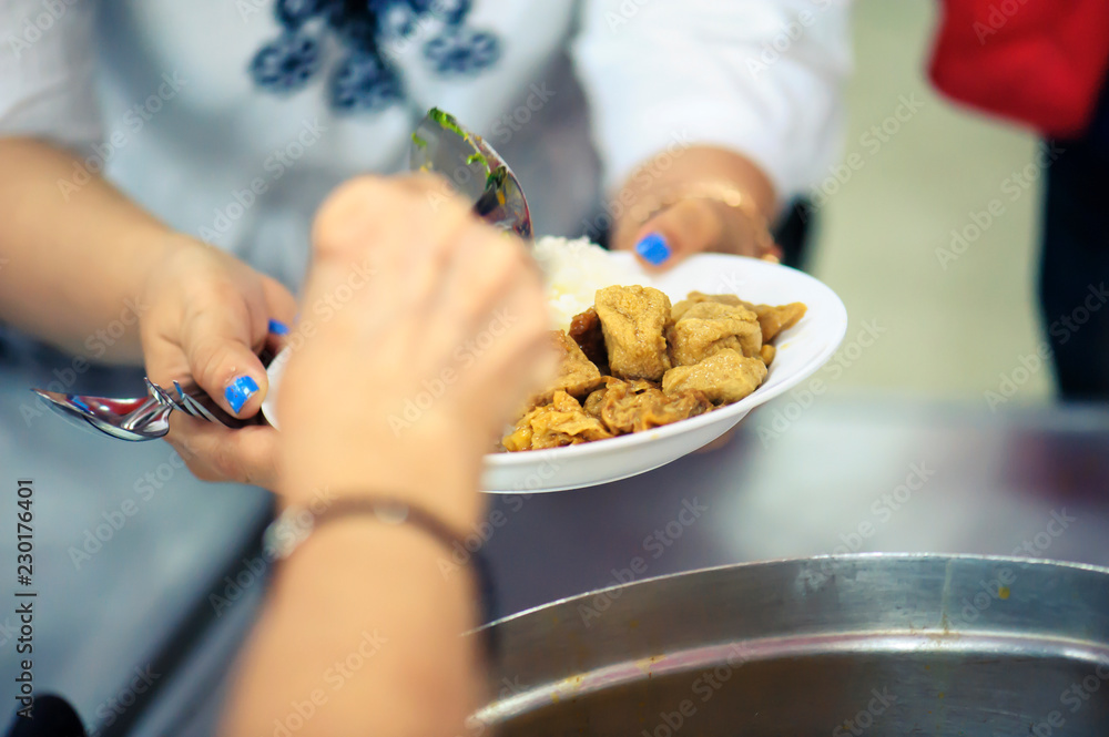 Fototapeta premium Sharing of food from volunteer hands to homeless people : The concept of feeding