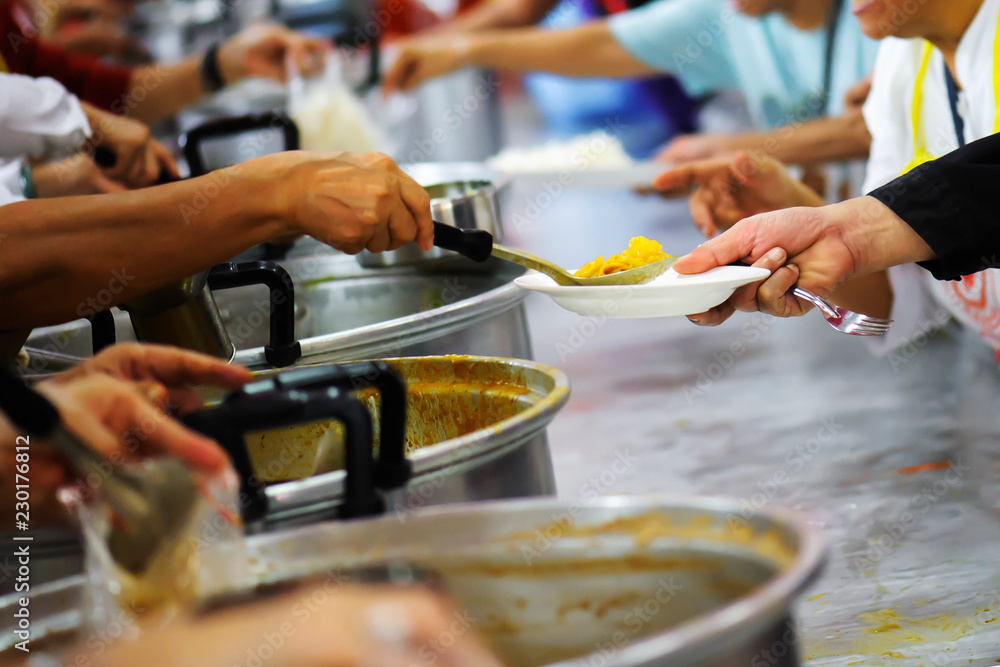 Fototapeta premium Sharing of food from volunteer hands to homeless people : The concept of feeding