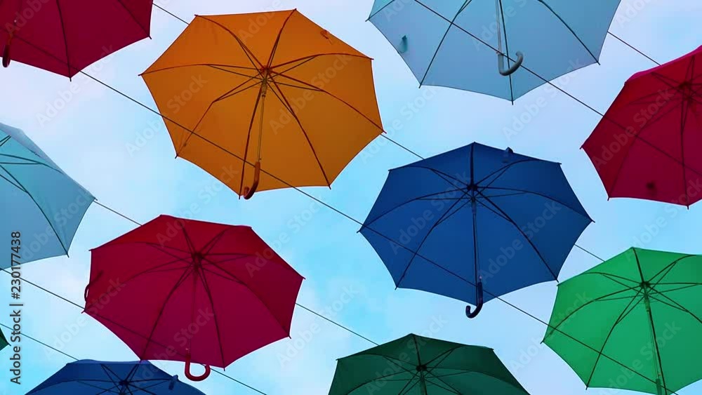 Flying Umbrellas. Multi colored Parasol Soar in the Sky. Umbrellas Suspended Above their Heads. Street Decorations of the City Flying Umbrellas. Multi colored Parasol Soar in the Sky. Umbrellas Suspended Above their Heads. Street Decorations of the City