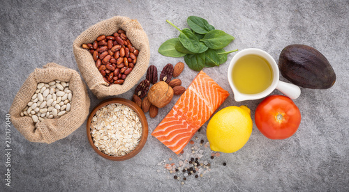 selection of healthy food. Salmon fish, nuts, salt, pepper, fruits and vegetables on stone background from top view.