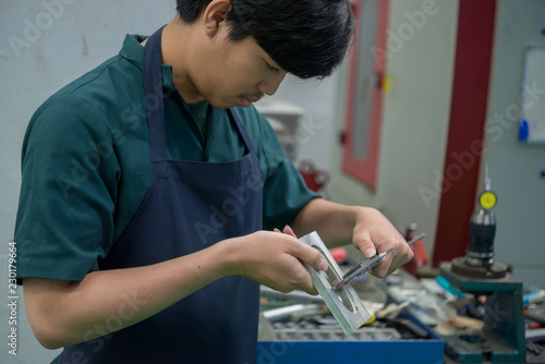 Mechanical engineer working at the plant of machine tools,Asian Lathe Technician at Work,Thailand people,Asian handsome industrial worker operating cnc machine
