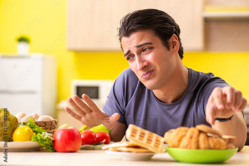 Man having hard choice between healthy and unhealthy food Man having hard choice between healthy and unhealthy food
