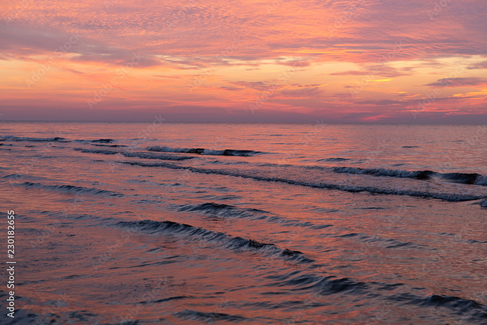 Purple orange sunset Baltic Sea and surf in autumn