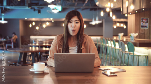 Asian businesswoman in casual suit with surprisingly or wow feeling when check the online shopping status by using the credit card at co-working space, business technology and lifestyle concept