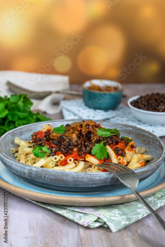 Kushari - Egyptian vegetarian dish with lentils, spiced tomato sauce and macaroni topped with fried onions