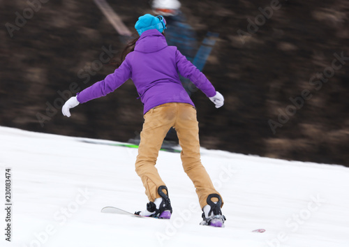 Girl snowboarding from the mountain in winter