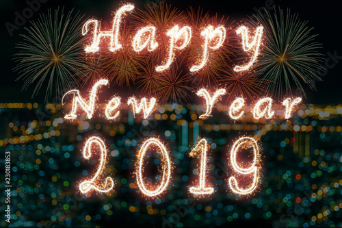 Happy new year 2019 written with Sparkle firework on fireworks with photo blurred of cityscape dark background, celebration and greeting cards concept