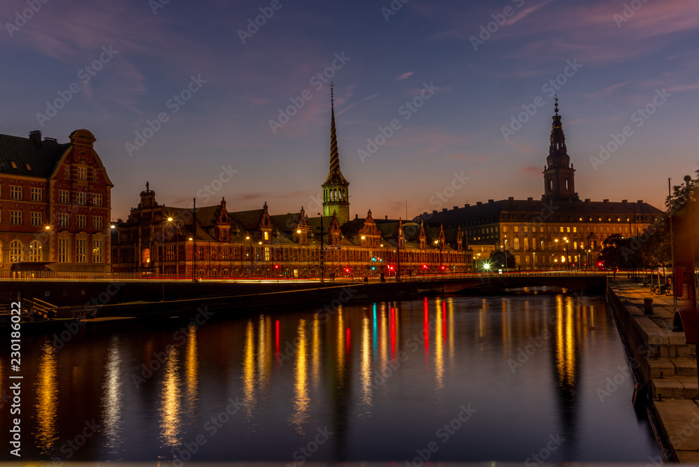 View of the Borsen (Danish for exchange) building in Copenhangen at night reflecting in the water channel - 1