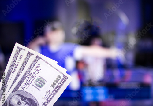 Money dollars on the background of a TV on which show sports archery, sports betting, archery, dollars