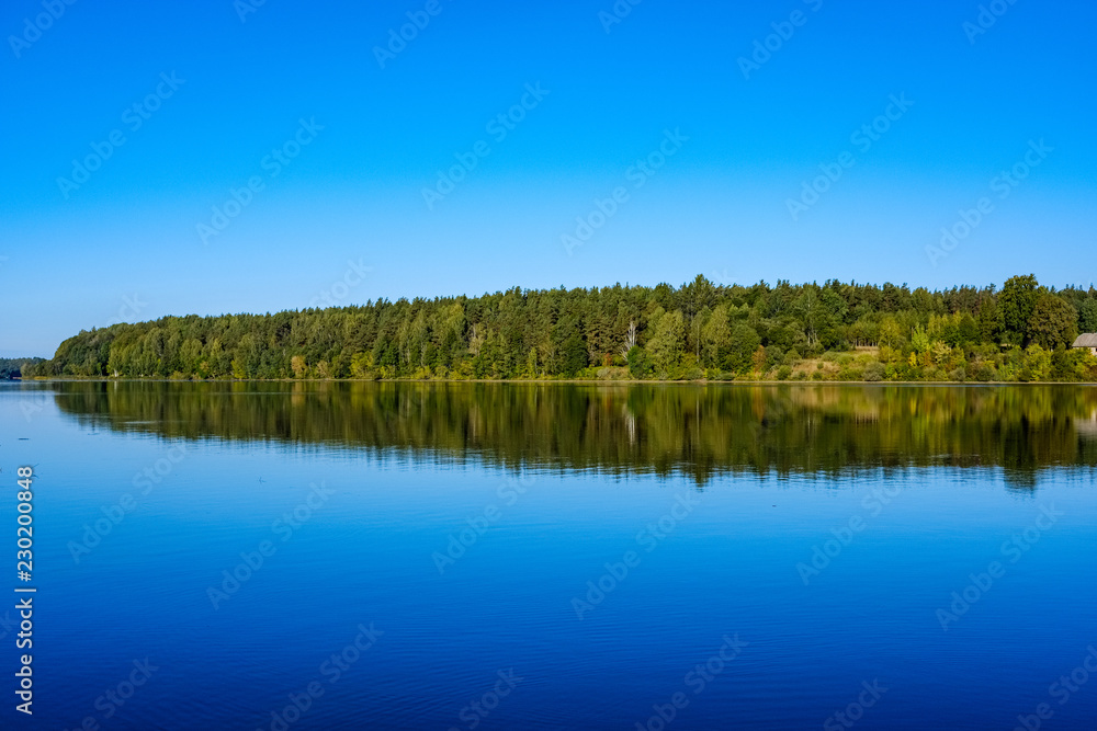 nature reflections in clear water in lake or river at countryside