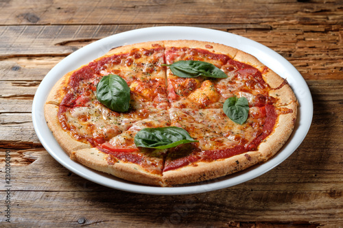 Pizza margherita with leaves of fresh basil