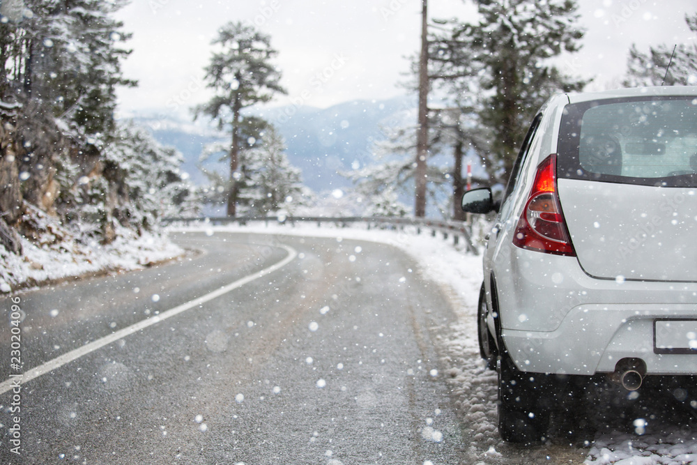 White car on a winter road through a snow covered forest. White car on a winter road through a snow covered forest.