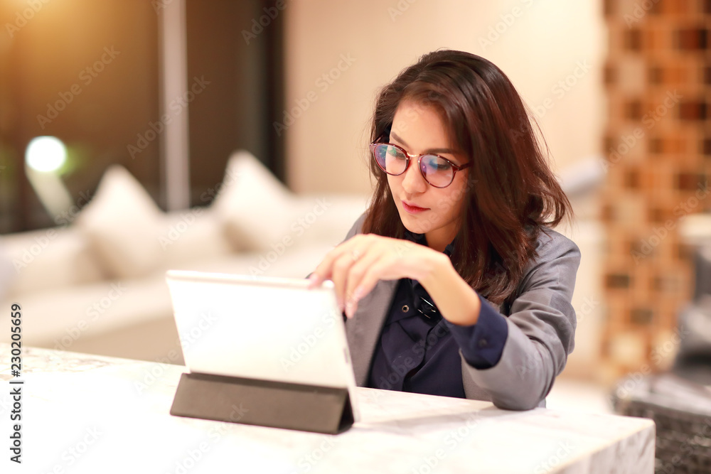 working and charming woman with glasses using tablet (work from home concept) working and charming woman with glasses using tablet (work from home concept)