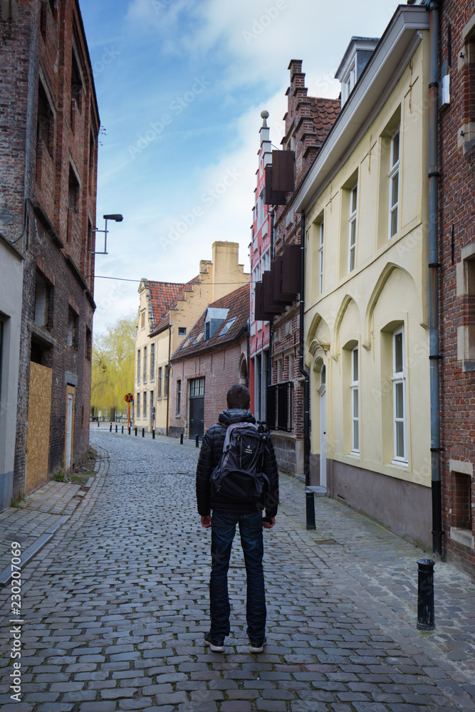 Traveler standing in small street in Gent